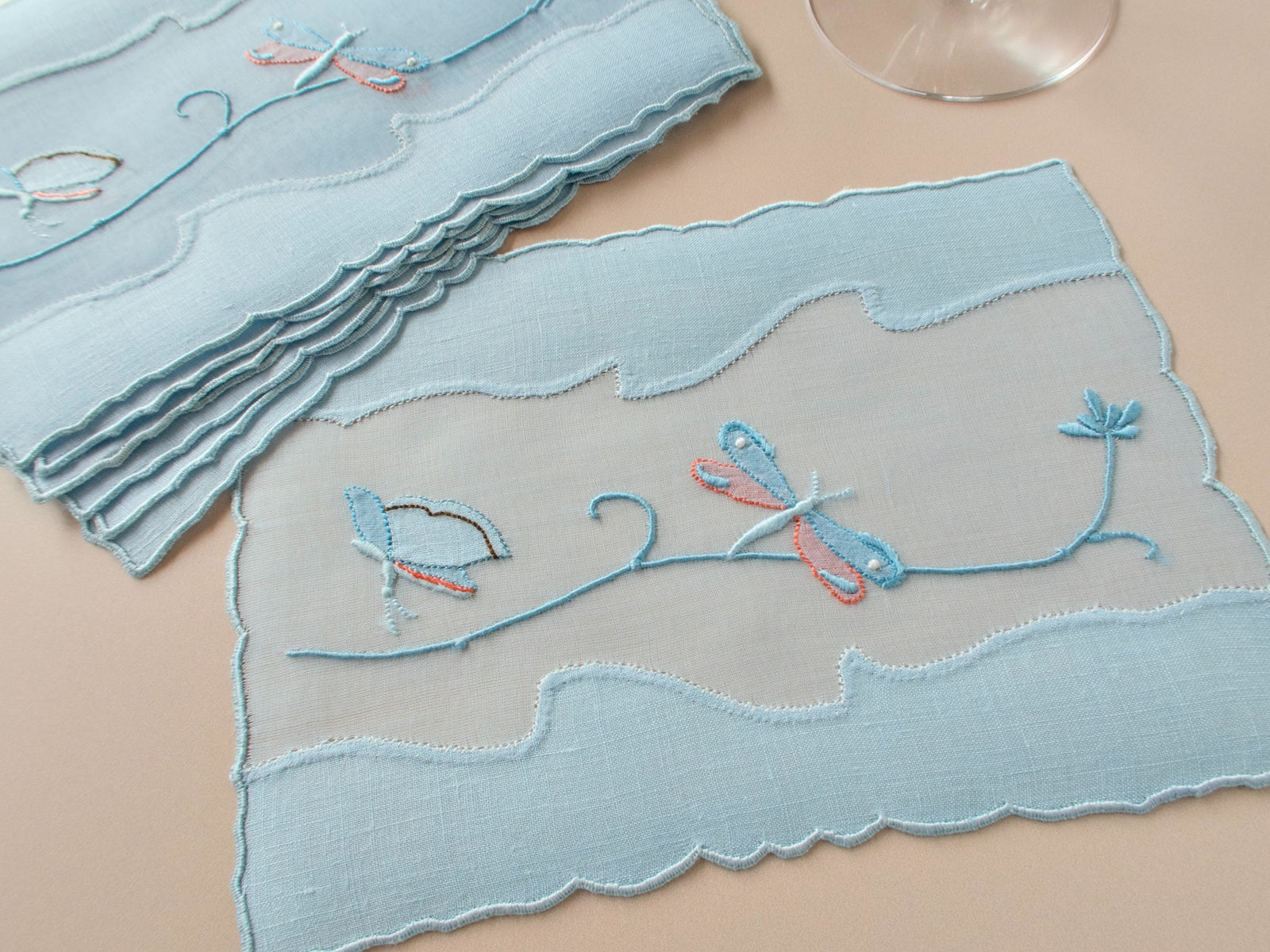 Vintage Madeira linen cocktail napkins with dragonflies and butterflies in shadow work and satin stitch within a sheer organdy window, showing scalloped border