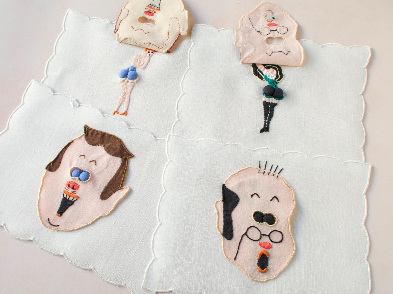 Vintage Madeira peek-a-boo cocktail napkins featuring embroidered men’s faces with padded ‘eyes’ that lift to reveal playful pin-up figures underneath.