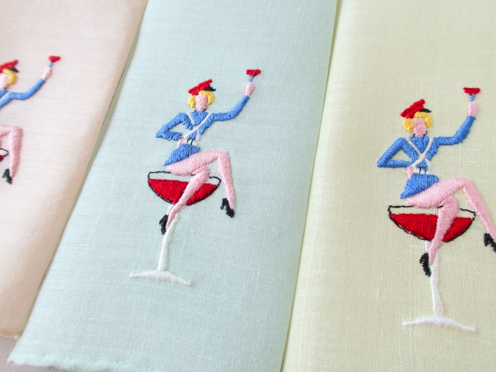 Vintage Italian hand embroidered cocktail napkins, showing sexy sailor figure with raised cocktail glass on semi-sheer pastel linen.