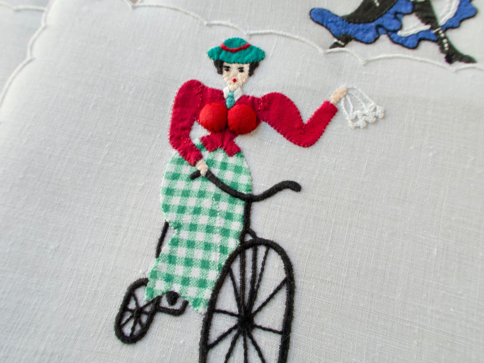 Close-up of vintage Madeira linen cocktail napkins by Paragon featuring playful hand-embroidered ladies with dimensional appliqué and bright colors