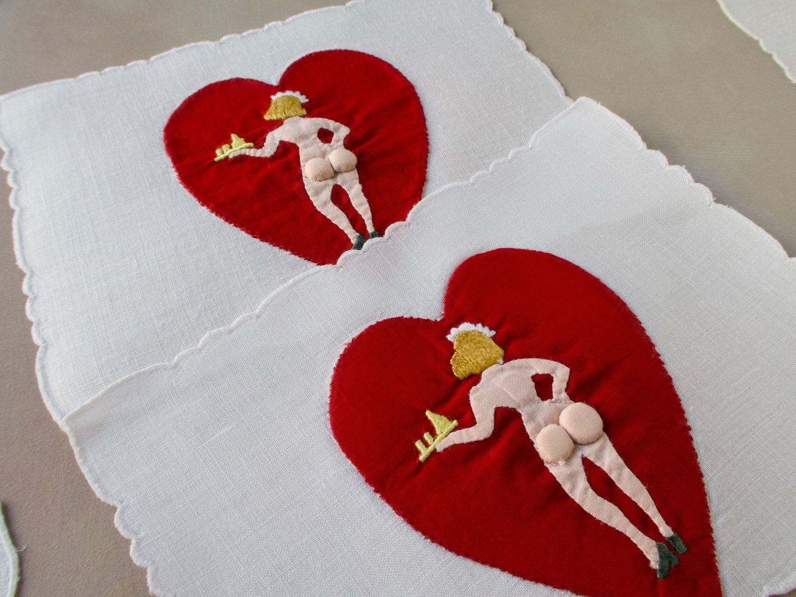Close-up of double-sided Madeira cocktail napkin showing padded embroidery on the heart appliqué.