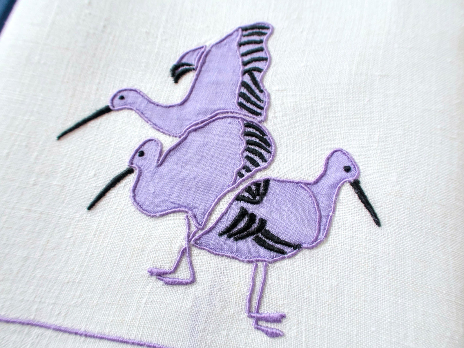 Close view of modernist water birds appliqué with bullrushes on vintage white linen hand towel, mid-century design.