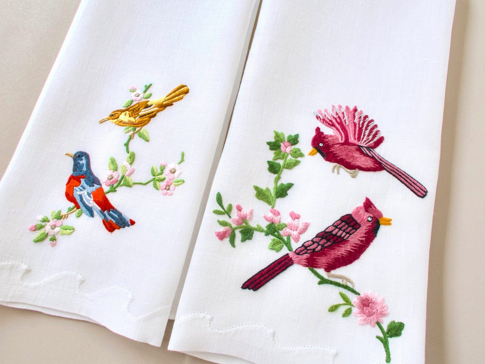 Two vintage Madeira Irish linen guest towels side by side showing full coordinating pair of bird embroidery designs
