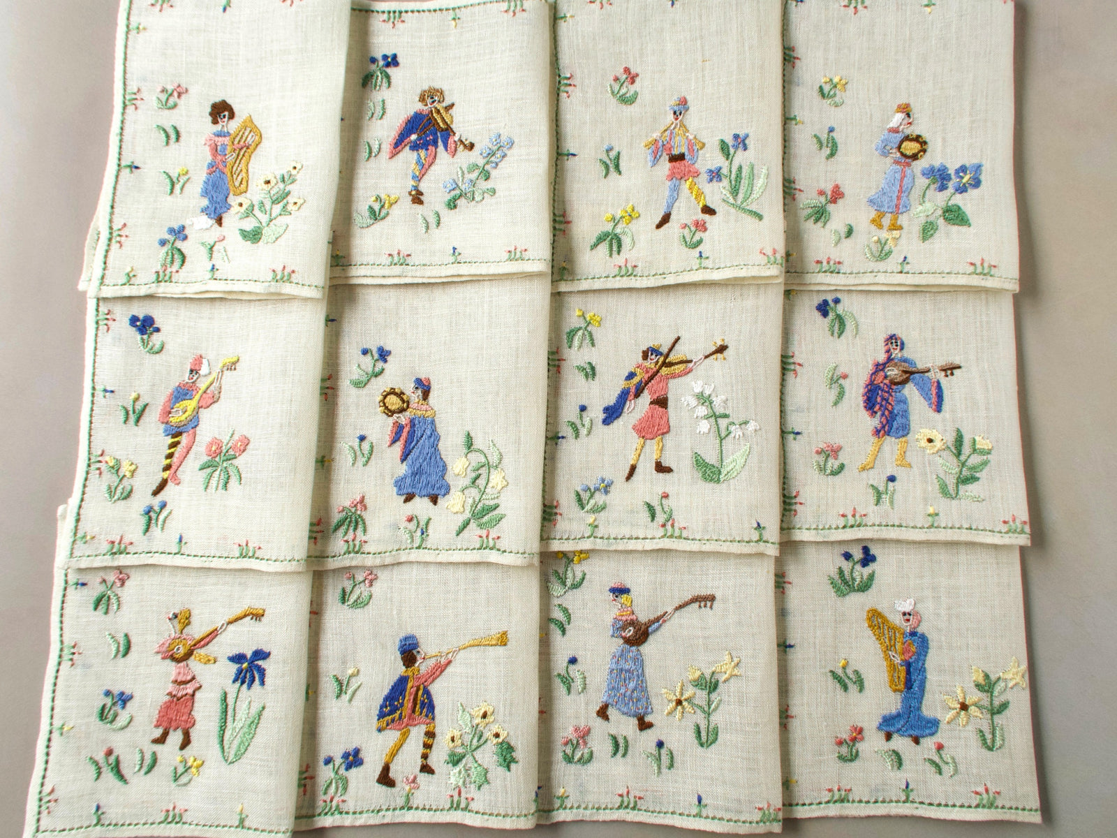 Full layout of all twelve Rapisardi medieval musician napkins arranged in a grid.