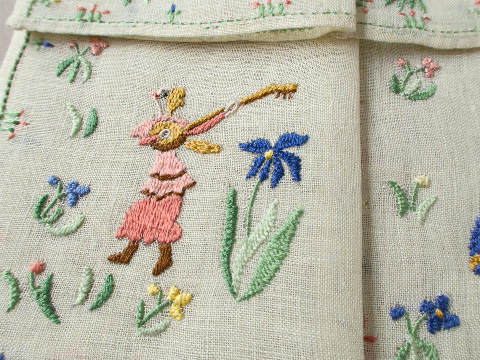 Close-up of a dancing female musician with pink dress on embroidered linen.
