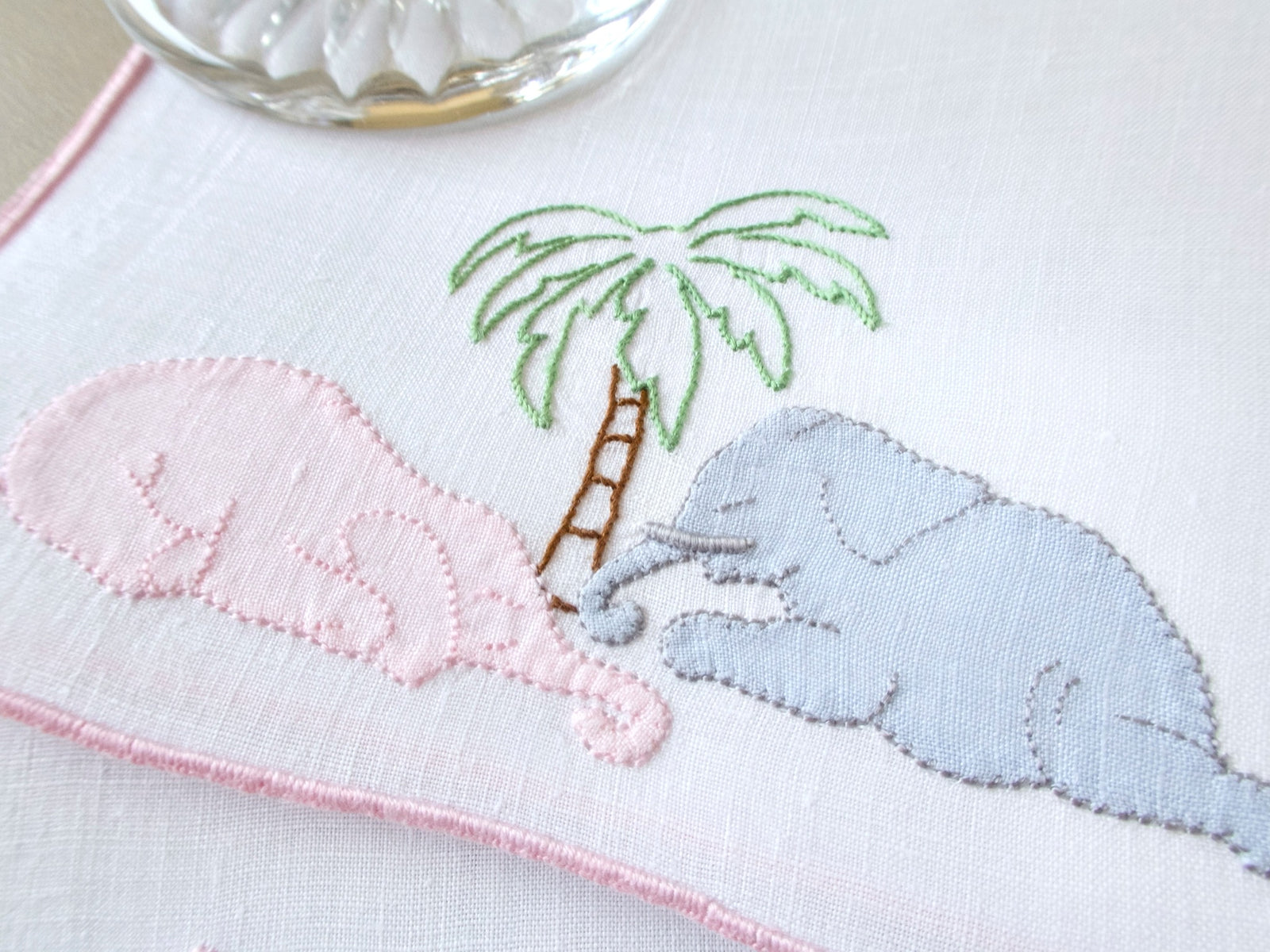 Vintage Madeira cocktail napkins, white linen with pink border, pink and gray appliqué elephants sleeping under a palm tree