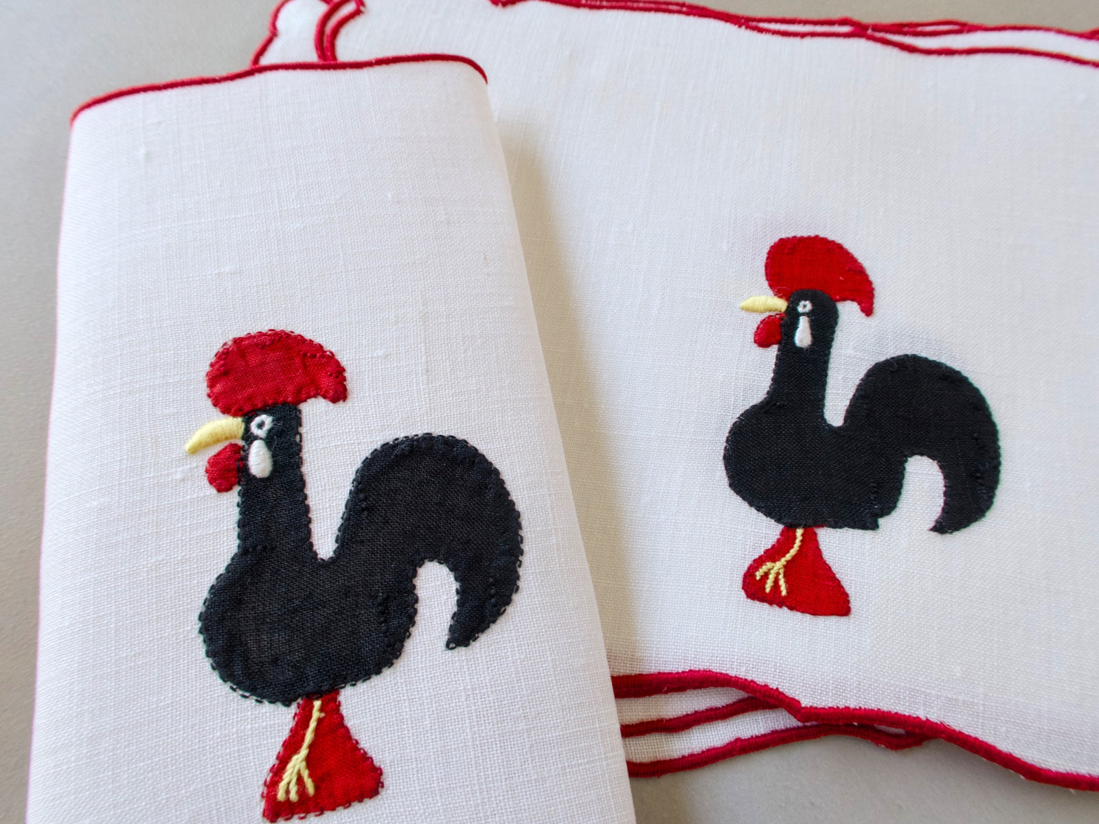 Vintage Madeira cocktail napkins, white linen with red scalloped border, black appliqué Barcelos rooster with red comb and feet