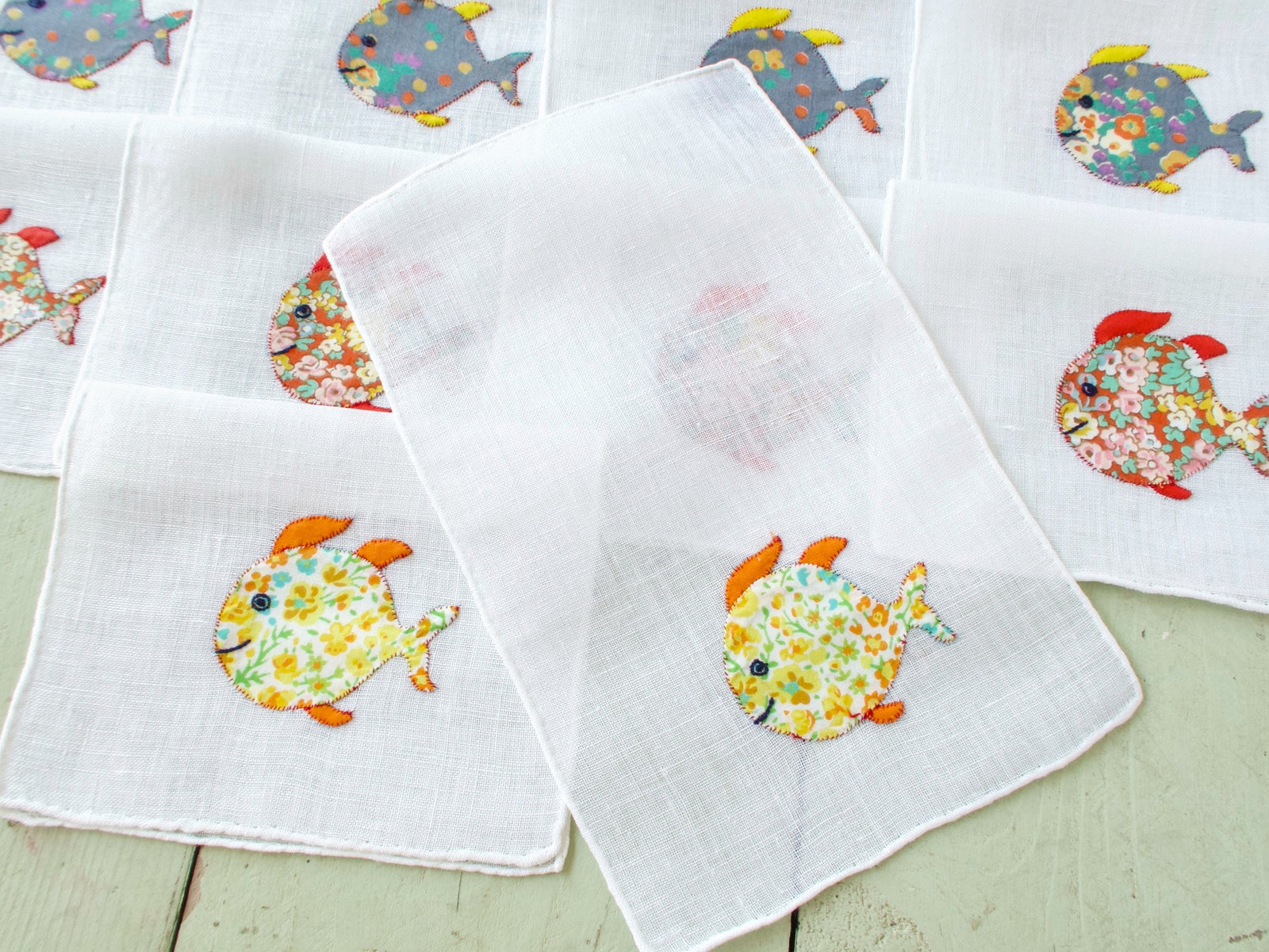 Single vintage Italian cocktail napkin, white semi-sheer linen with colorful floral appliqué fish