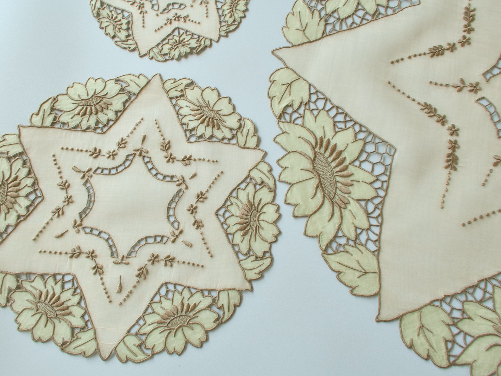 Full vintage Madeira 17-piece round placemat set laid out showing star-shaped placemats, coasters and centerpiece with sunflower border