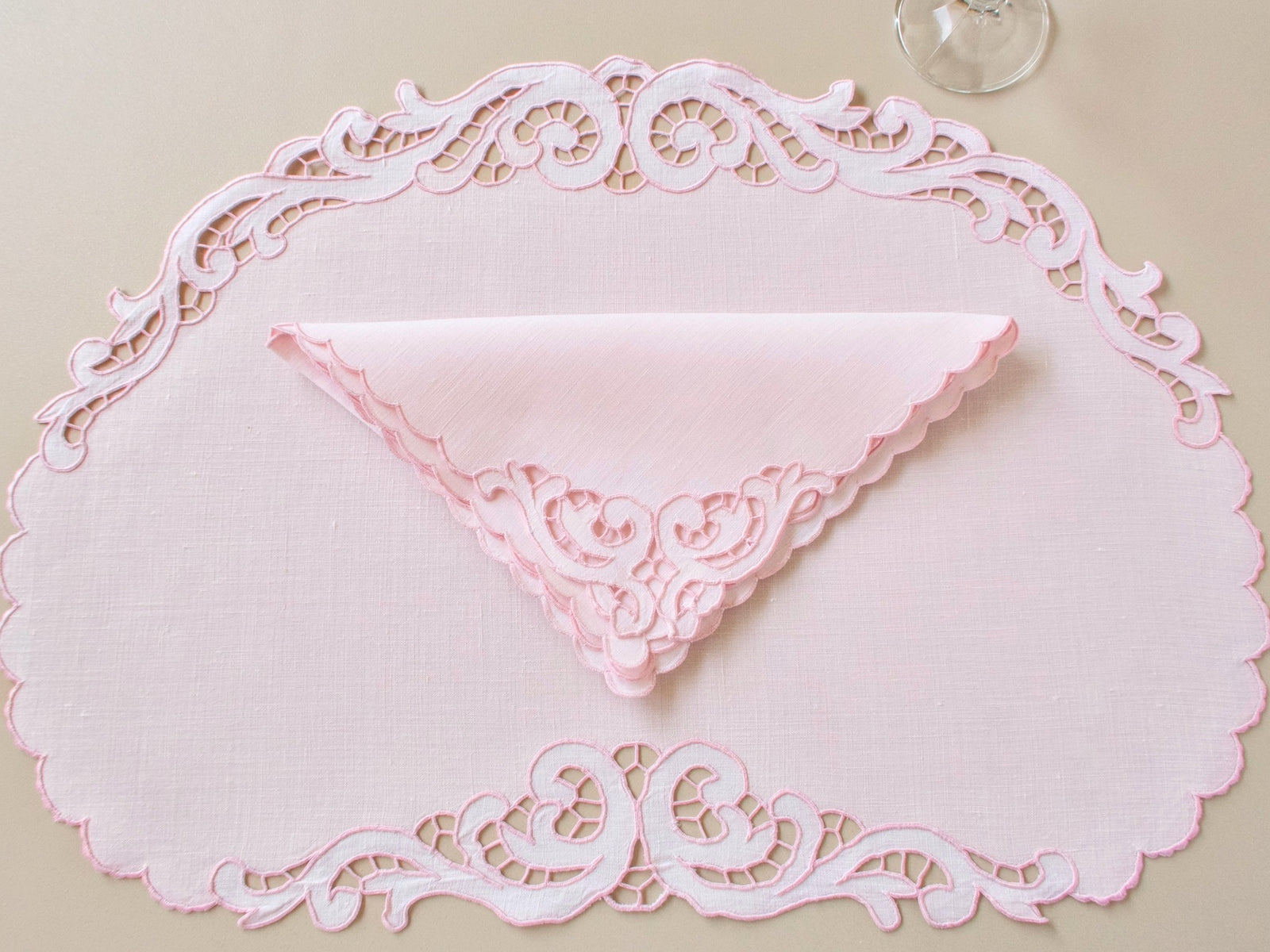 Oval vintage Madeira pink Irish linen placemat with folded napkin showing full scrollwork Richelieu cutwork border
