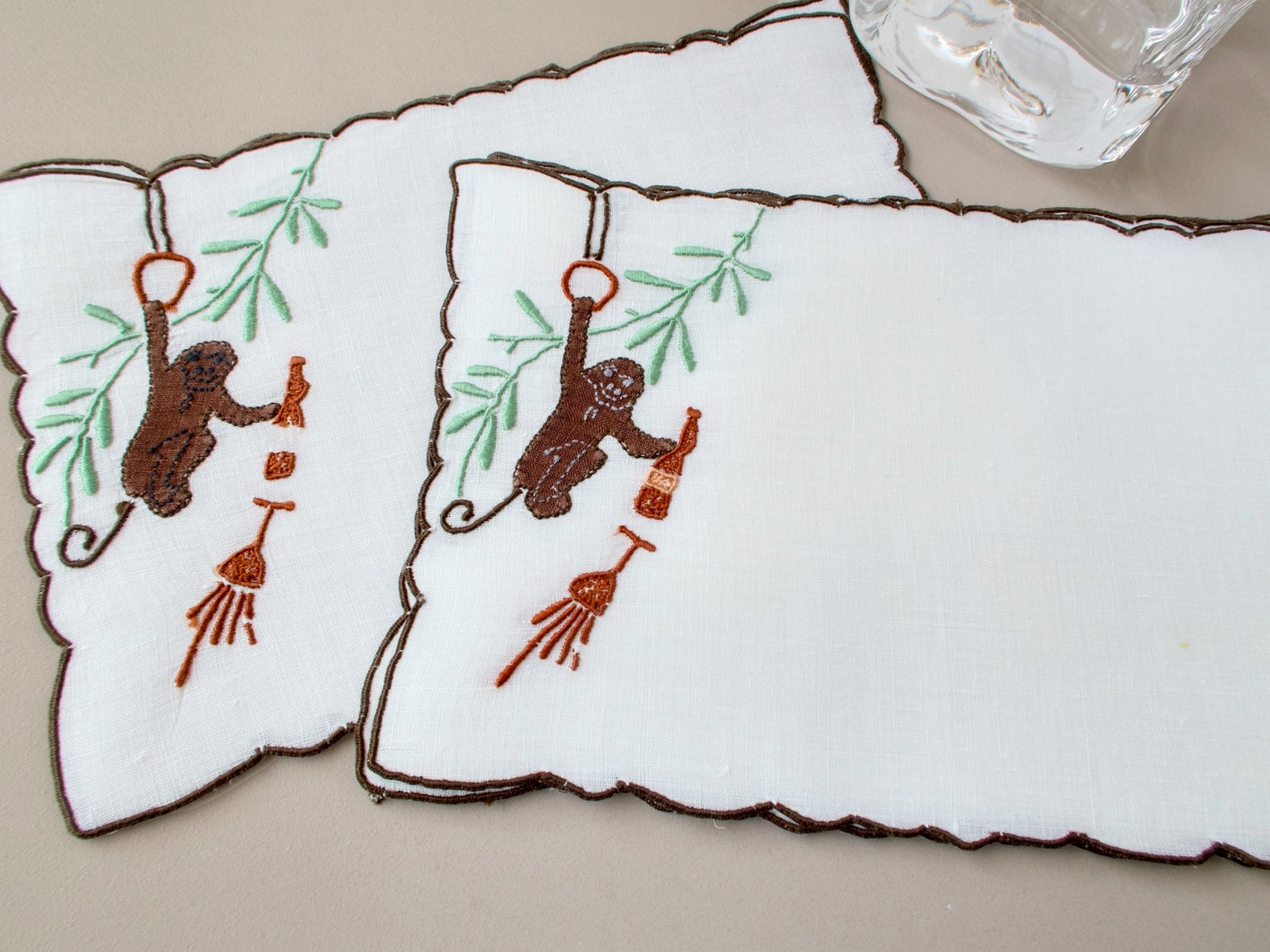 Two vintage Madeira cocktail napkins showing incomplete bottle motif on one napkin, condition variation disclosed