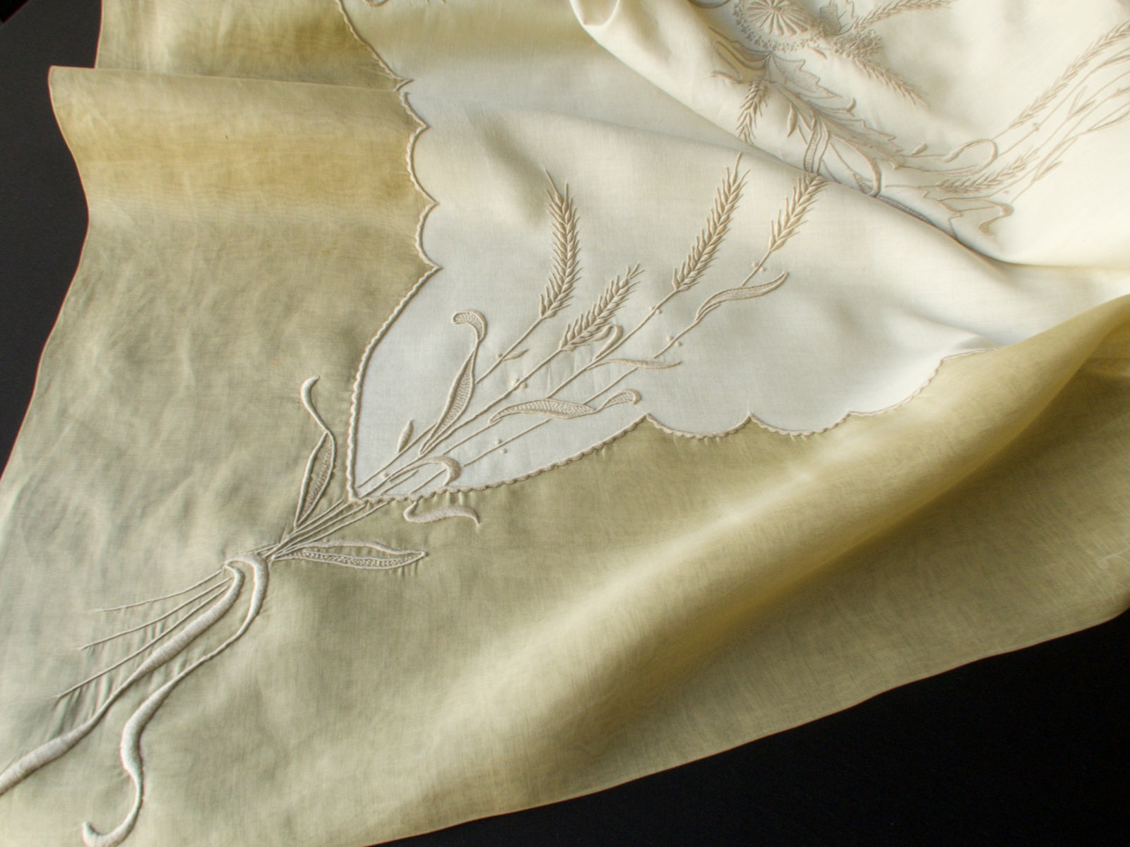 Border of Marghab Wheat tablecloth with padded wheat embroidery and crisp hem, hand-finished in Madeira.