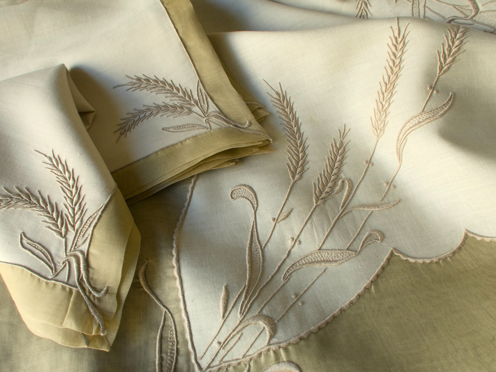 Marghab Wheat tablecloth photographed in natural light, highlighting texture and sheen of the fine linen embroidery.