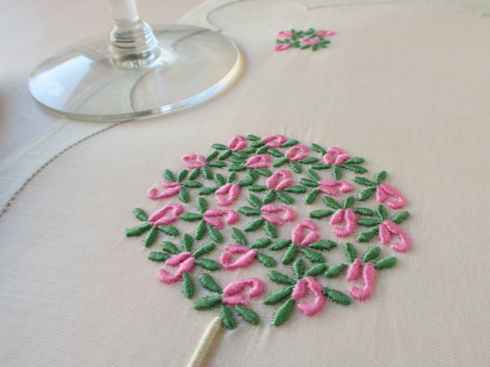 Close-up of hand embroidered pink rose topiary on vintage Madeira organdy placemat with linen napkin.