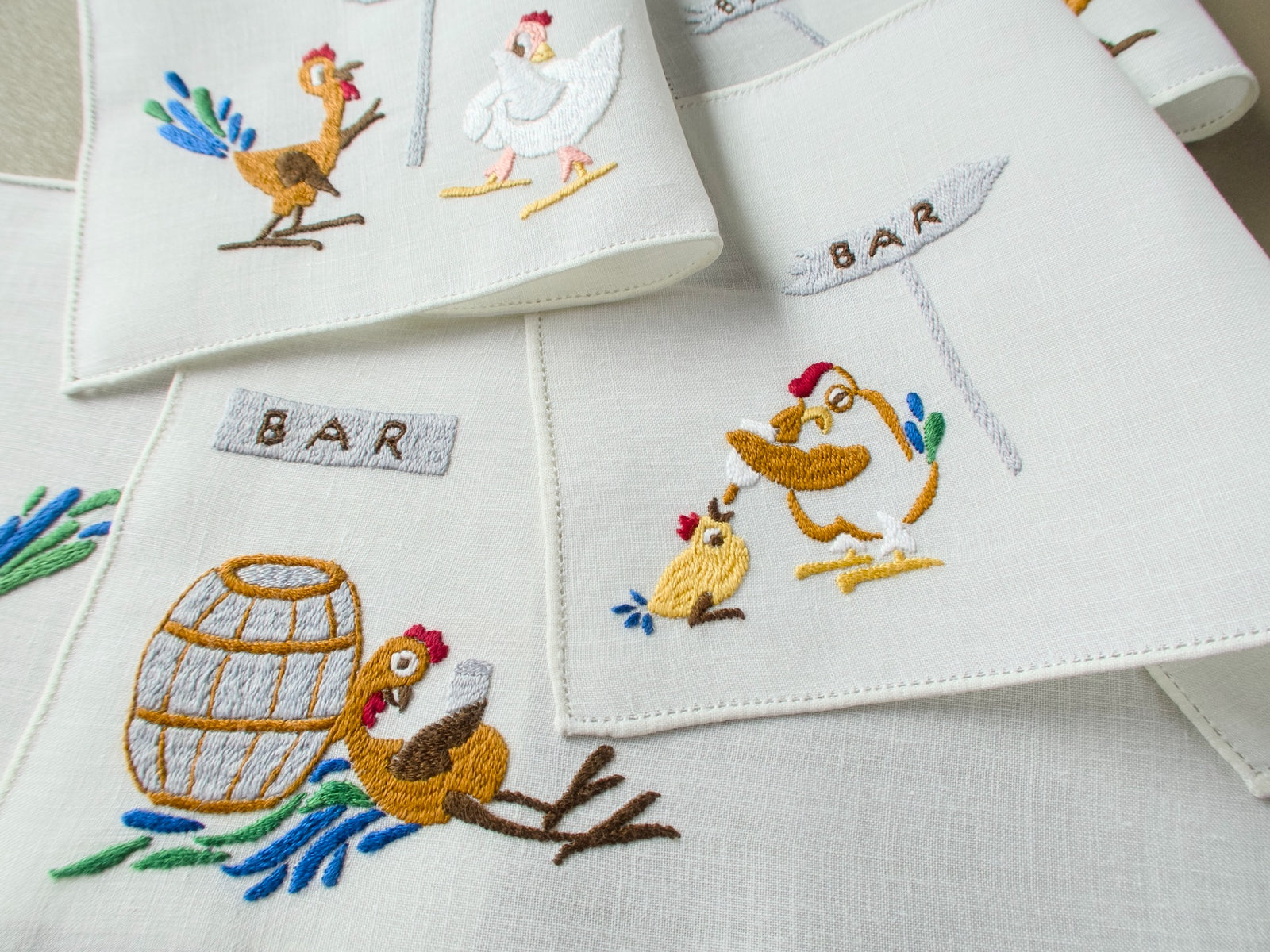 Vintage Rapisardi linen cocktail napkins with a rooster at a barrel and a bleary-eyed hen feeding a chick