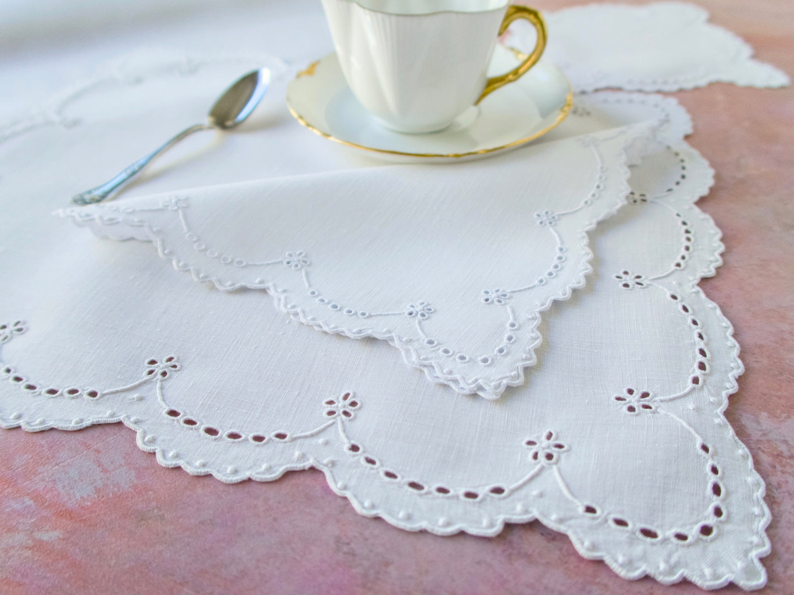Detail of white eyelet embroidery with scalloped edges on Irish linen placemat, showing broderie anglaise design