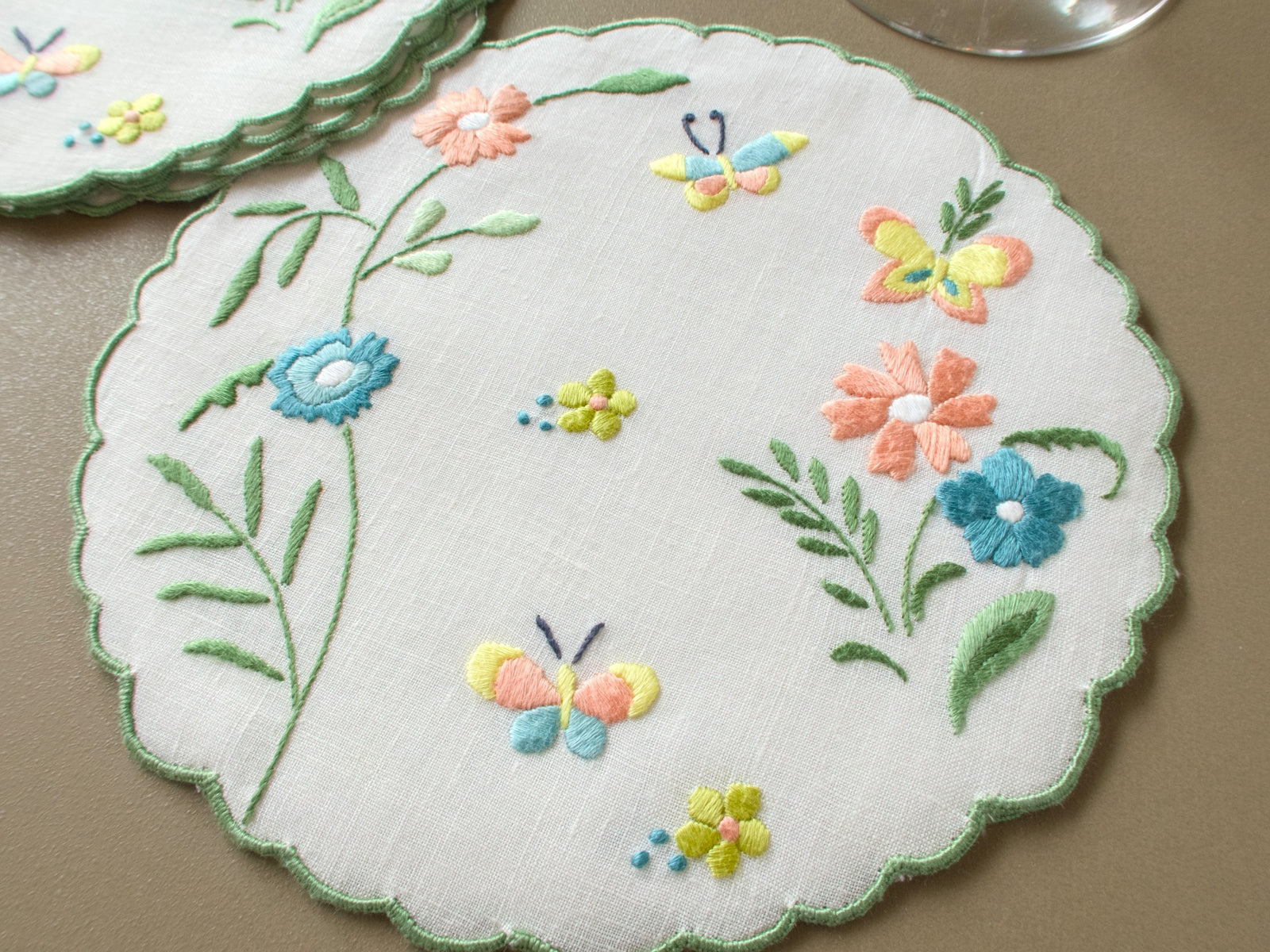 Single vintage Madeira linen cocktail round with embroidered butterflies, flowers and leafy stems
