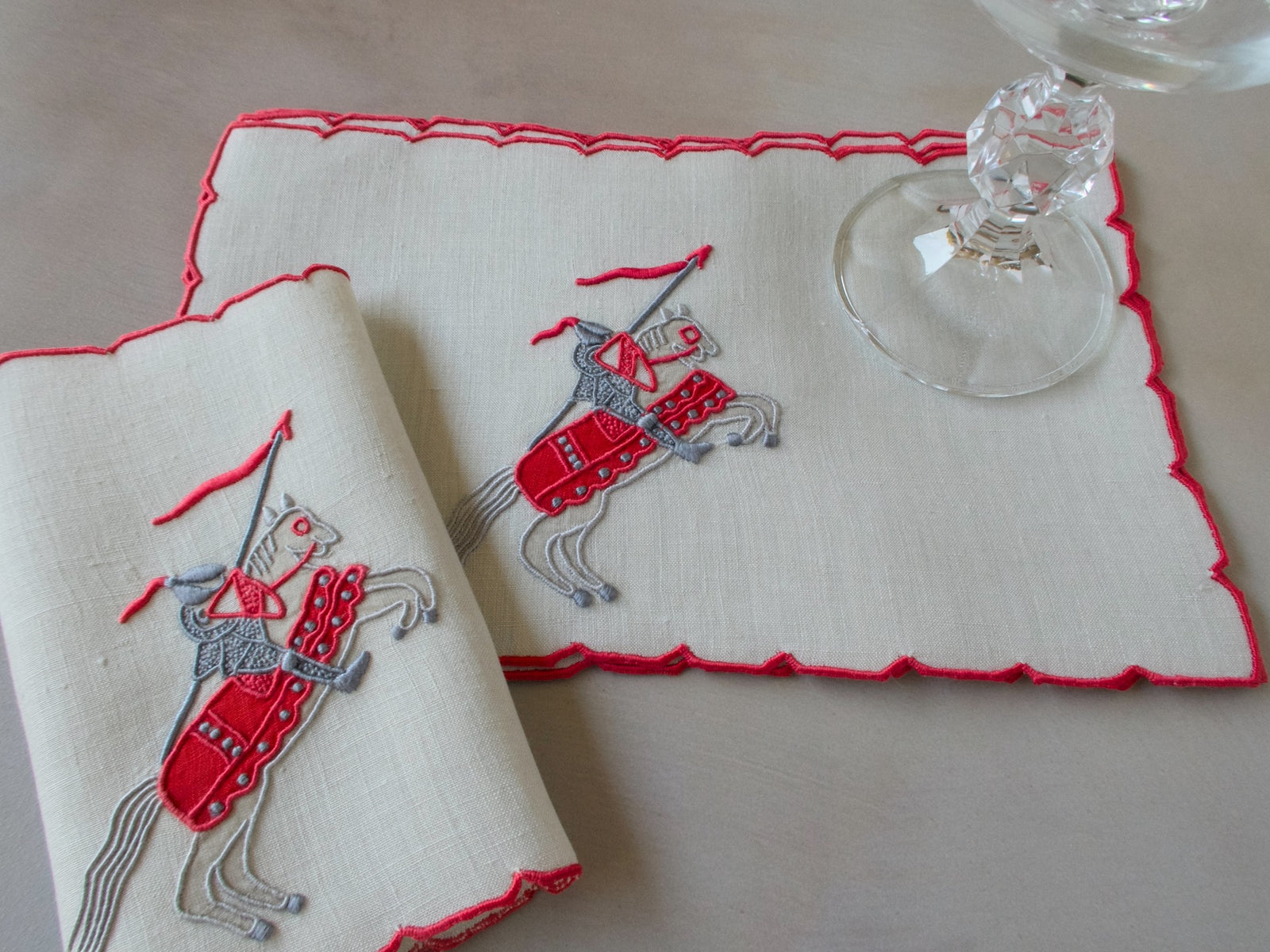 Vintage Marghab Knight pattern cocktail napkins, red embroidery on oyster-colored linen showing knight on horseback, handmade in Madeira.