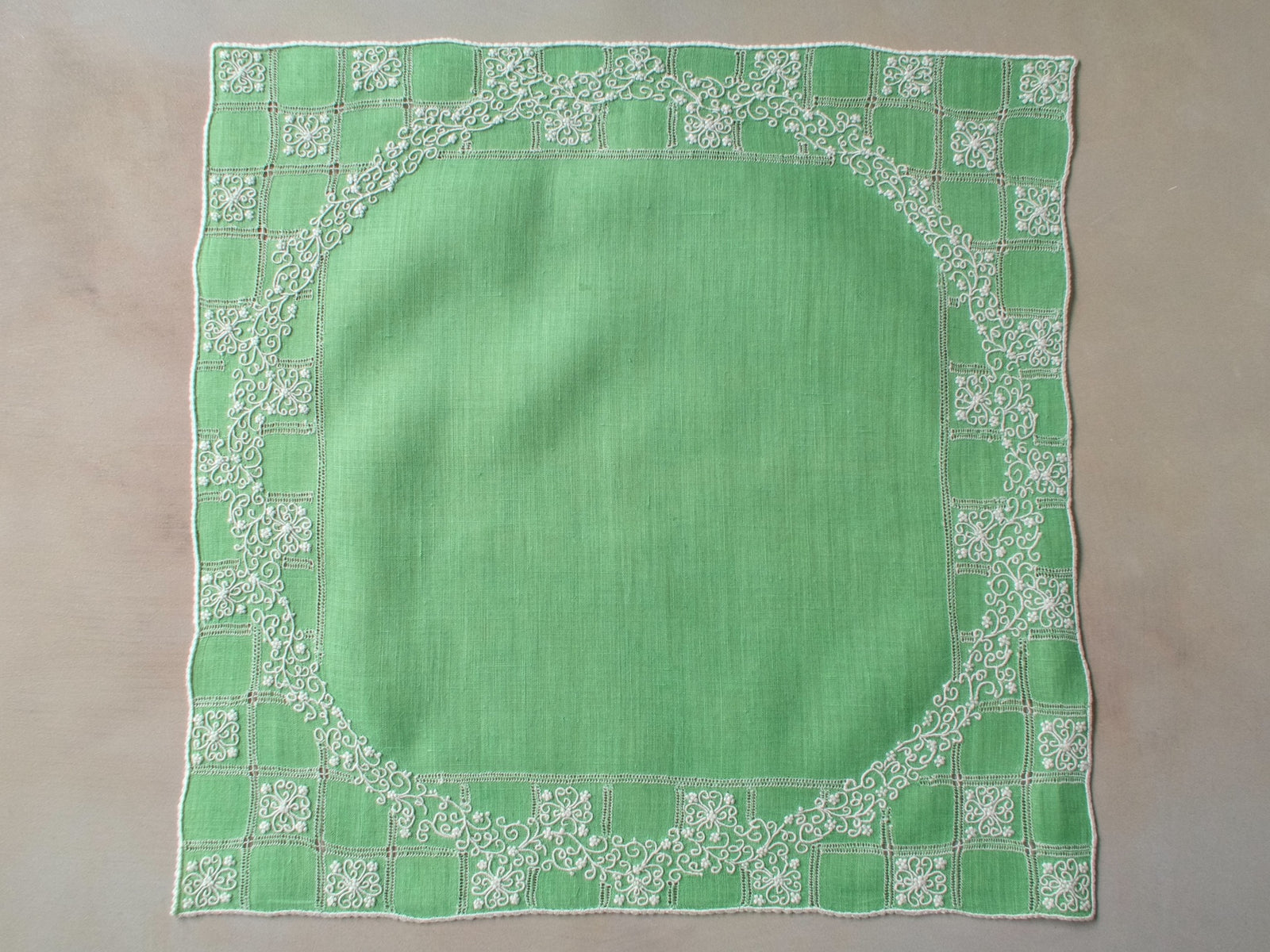 Vintage Marghab “Wreath Over Square” handkerchief, hand embroidered in white on green linen with intricate raised stitching and fine caseado bastido edging.