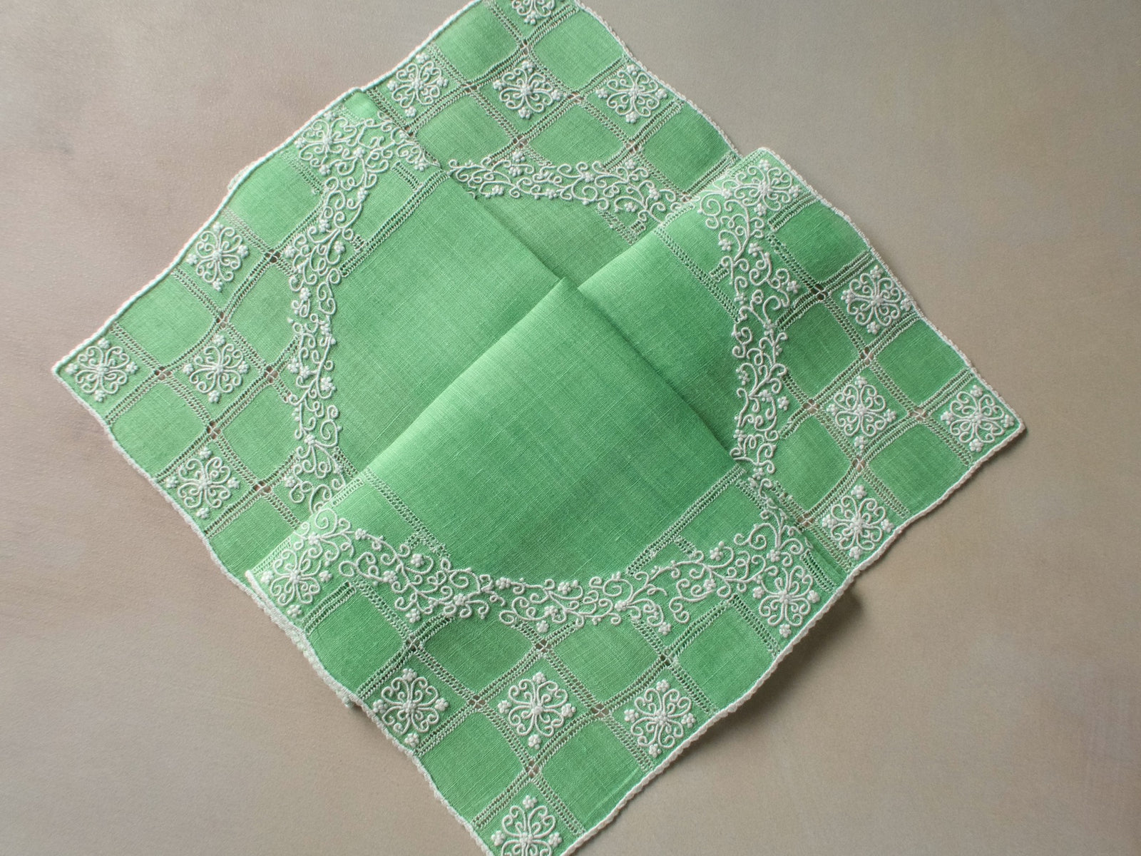 Vintage Marghab “Wreath Over Square” handkerchief, hand embroidered in white on green linen with intricate raised stitching and fine caseado bastido edging.