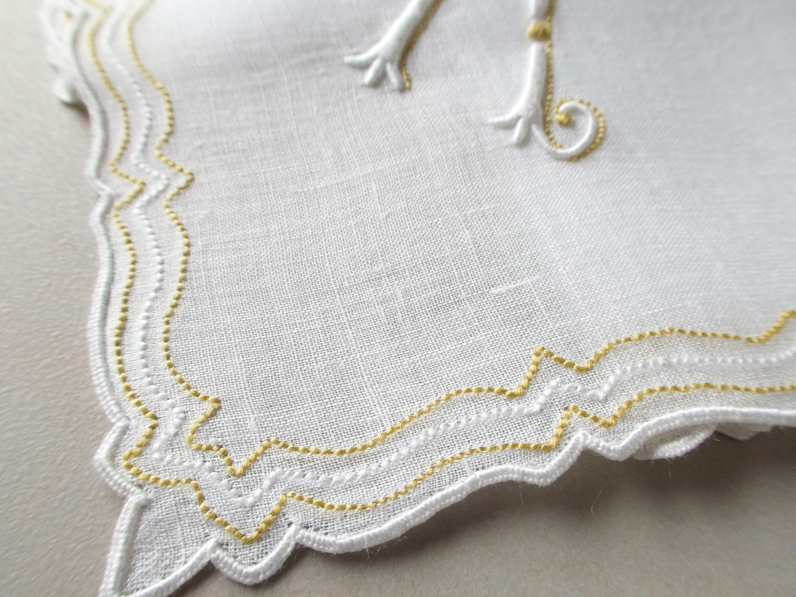 Vintage Marghab handkerchief in the “Initials” pattern, featuring a gold-embroidered “K” monogram with scalloped white border on fine linen. Hand embroidered in Madeira.