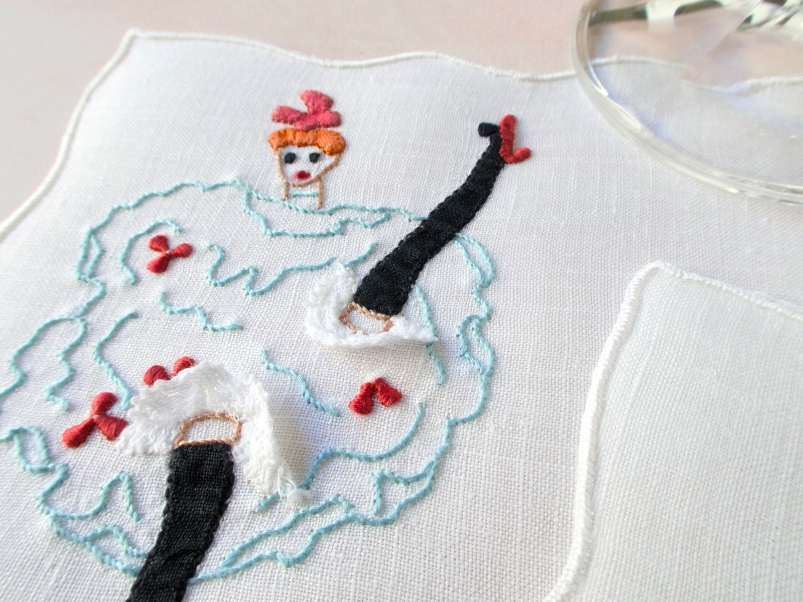 Vintage Madeira cocktail napkin with embroidered can-can dancer, frilly knickers, and applied lace.
