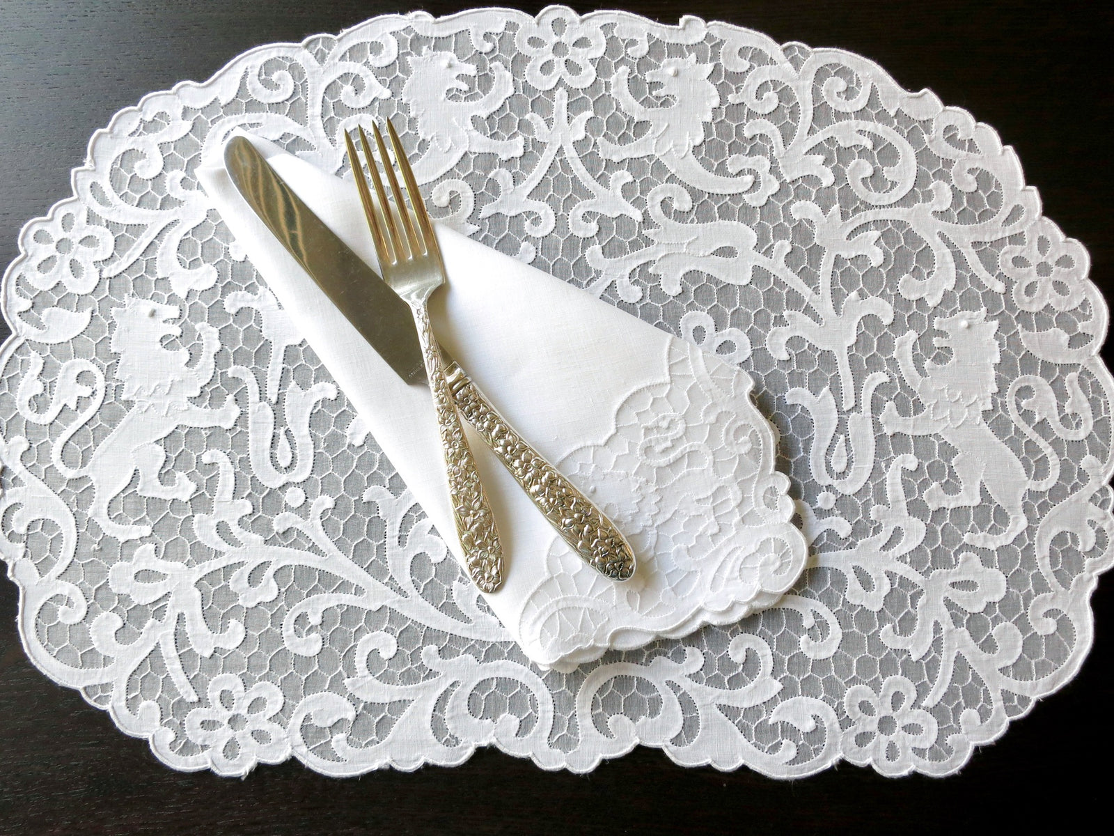 Vintage Madeira linen placemat and napkin set featuring heraldic lion embroidery on a delicate honeycomb background.