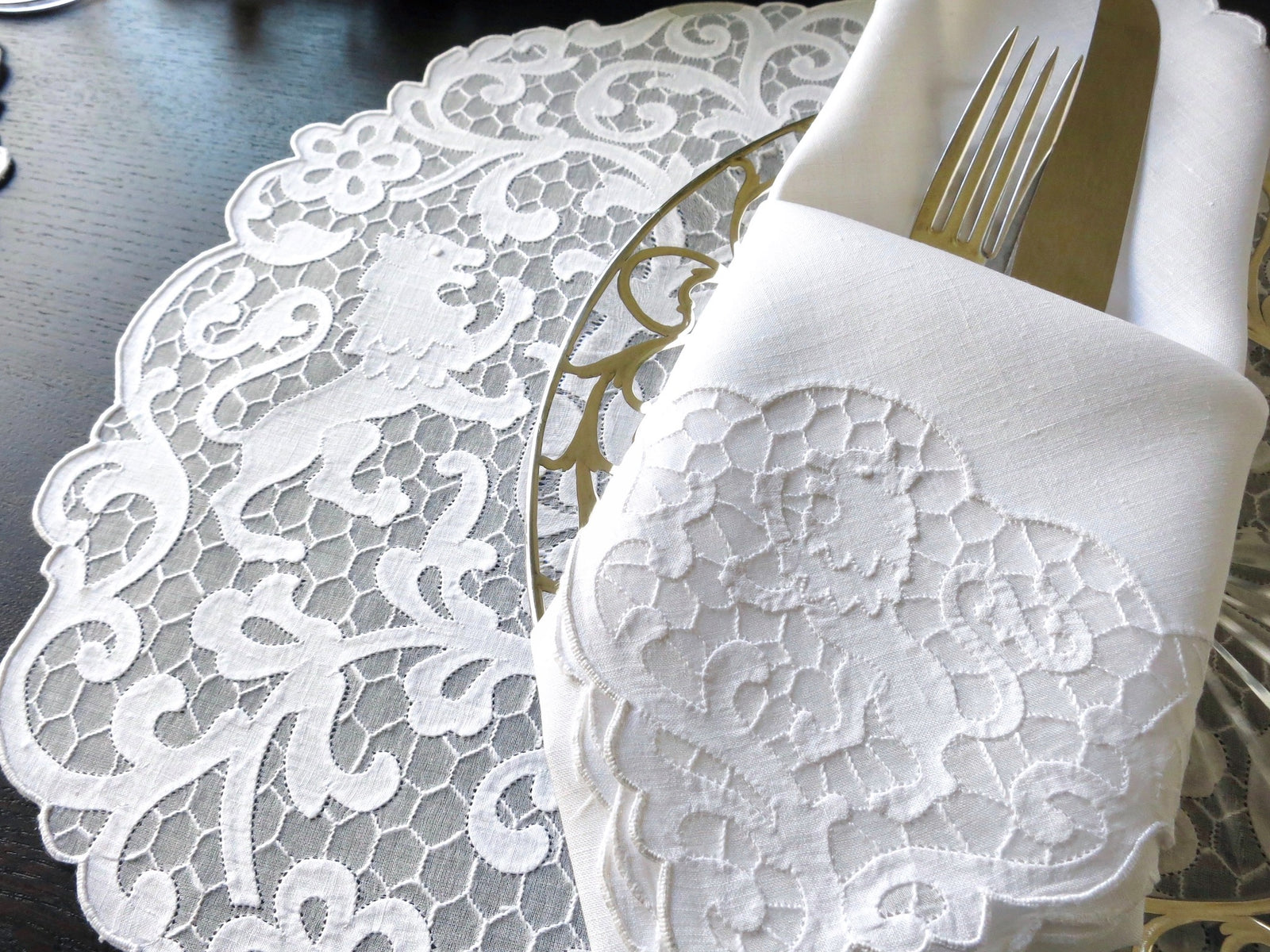 Vintage Madeira linen placemat and napkin set featuring heraldic lion embroidery on a delicate honeycomb background.
