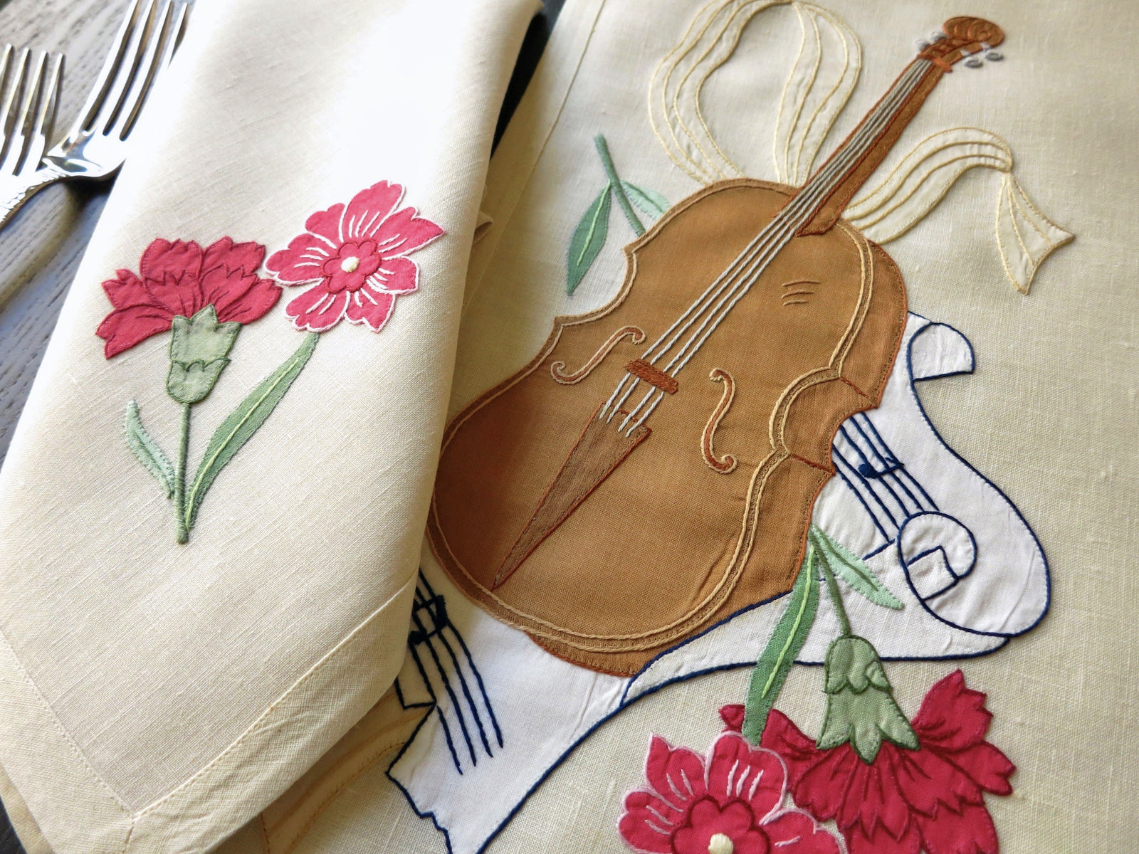 Detailed view of a vintage Italian embroidered placemat with a musical instrument and flowers.
