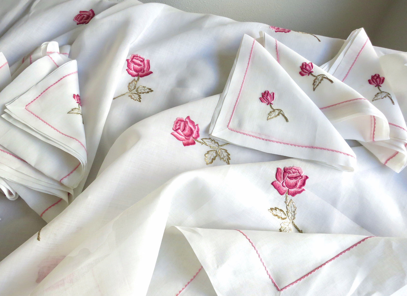 Vintage European cotton batiste napkins and tablecloth hand embroidered with scattered pink rosebuds and pink borders, showing full set