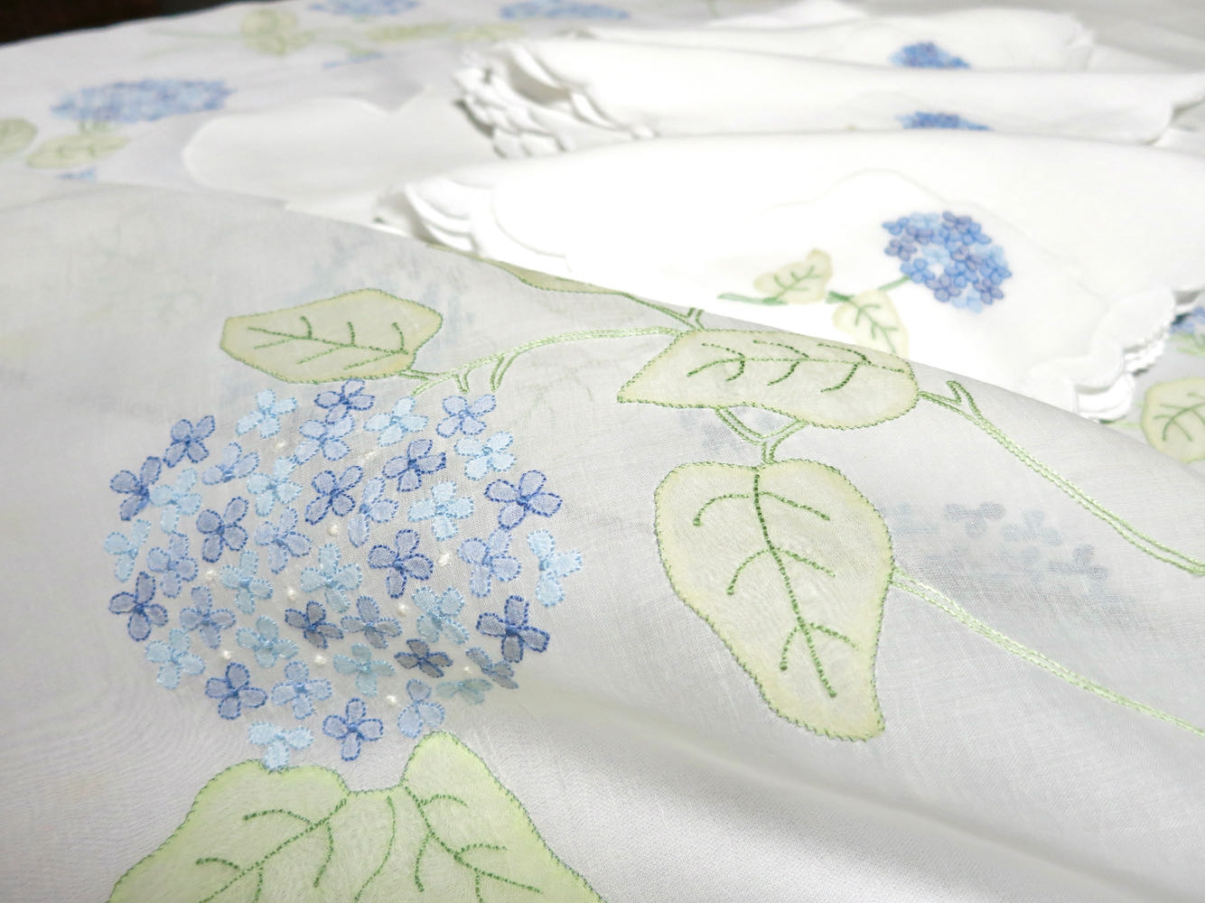 Detail of Madeira organdy tablecloth with hand embroidered hydrangea blossoms.