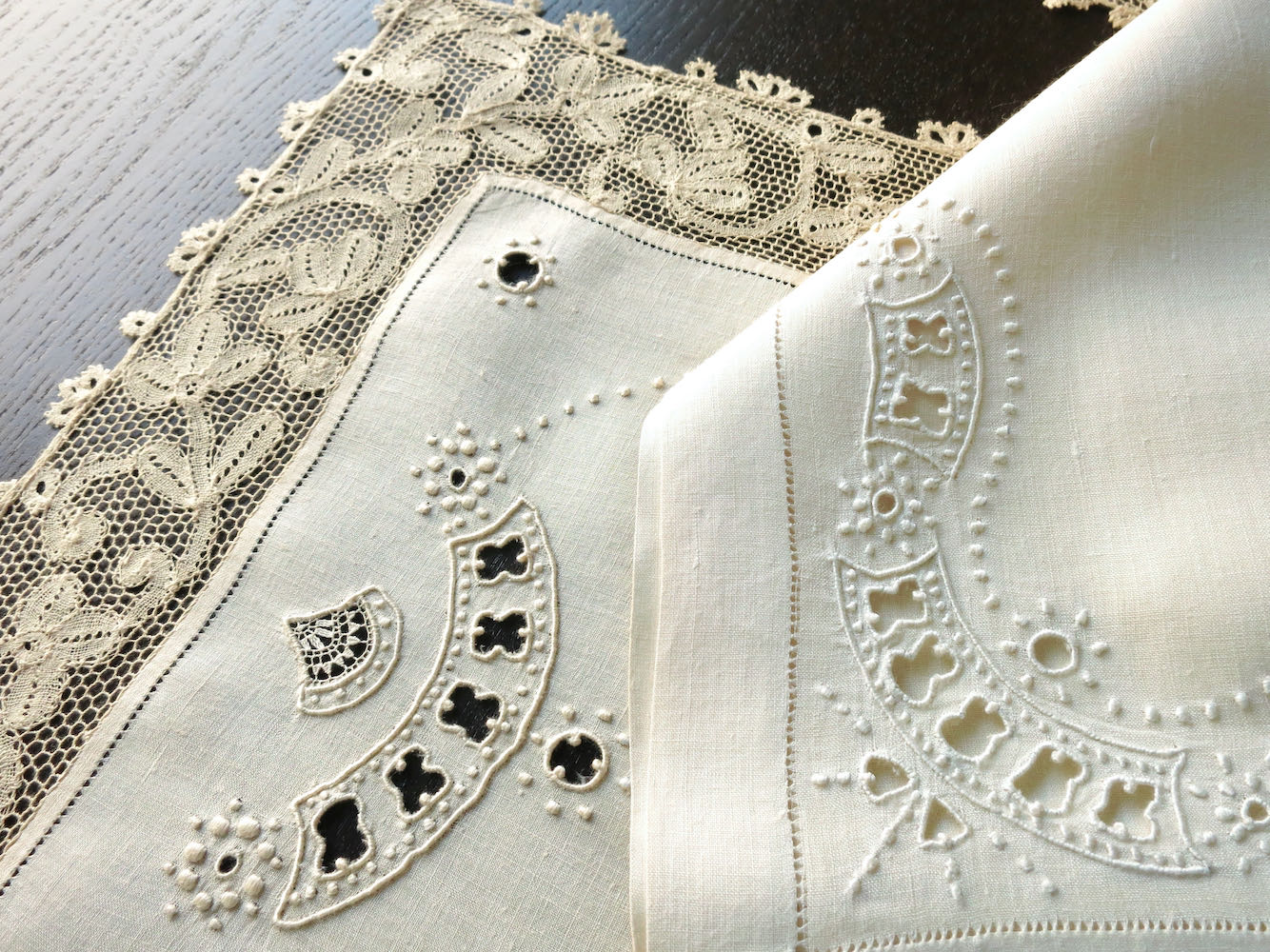Detailed view of a vintage Milanese lace and linen placemat set, with intricate embroidery.