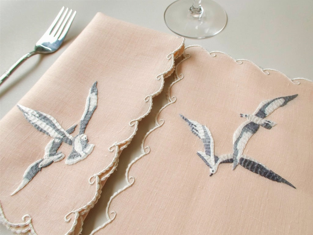 Close view of vintage Madeira hand embroidered seagulls, grey and white feather shading on coral Irish linen, extraordinary detail.