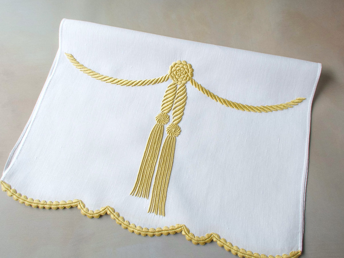 Vintage Marghab linen towel in the “Cord &amp; Tassel” pattern, hand embroidered in gold with twin tassels and scalloped edge.