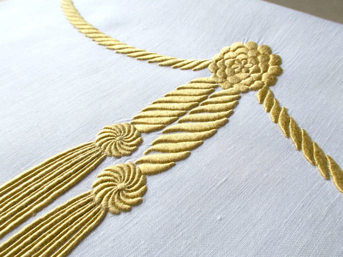 Vintage Marghab linen towel in the “Cord &amp; Tassel” pattern, hand embroidered in gold with twin tassels and scalloped edge.
