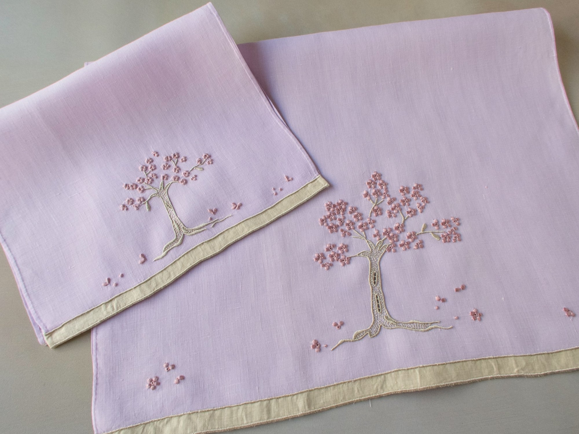 Marghab linen towels in the “Jacaranda Tree” pattern, featuring an embroidered jacaranda tree in bloom — guest and fingertip sizes shown together.