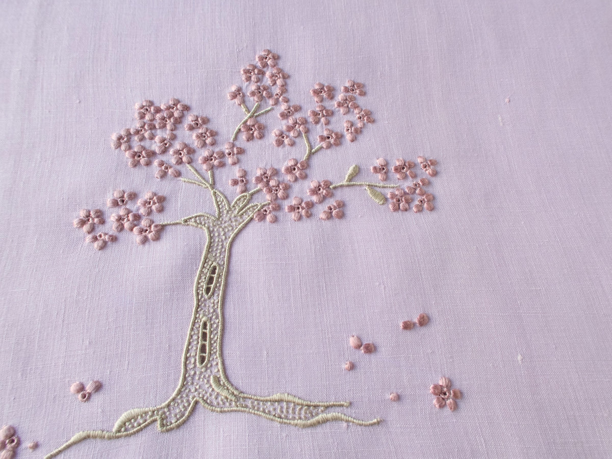 Marghab linen towels in the “Jacaranda Tree” pattern, featuring an embroidered jacaranda tree in bloom.