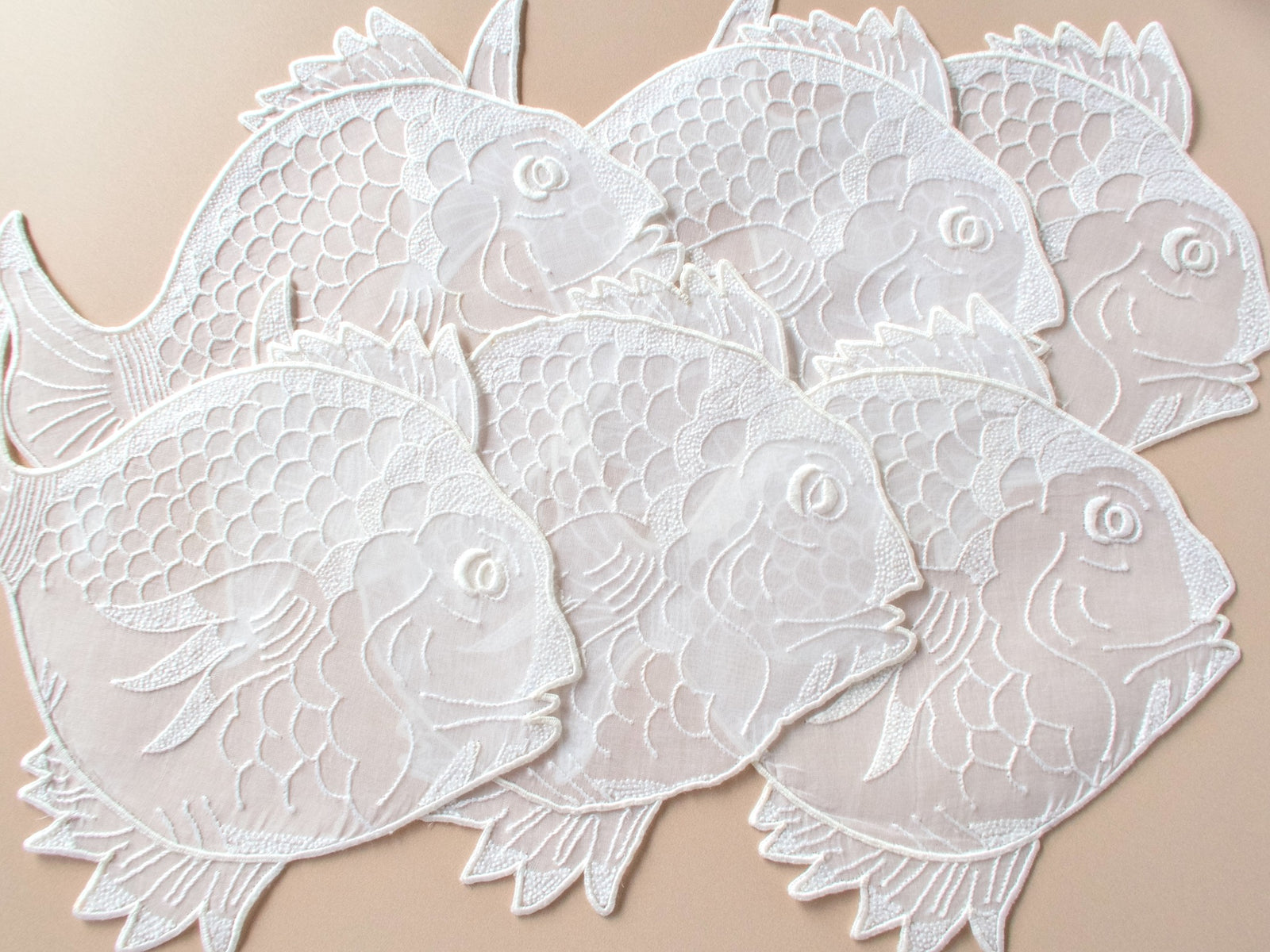 Set of fish-shaped vintage Madeira organdy cocktail napkins showing detailed hand embroidery on sheer organdy​​​​​​​​​​​​​​​​