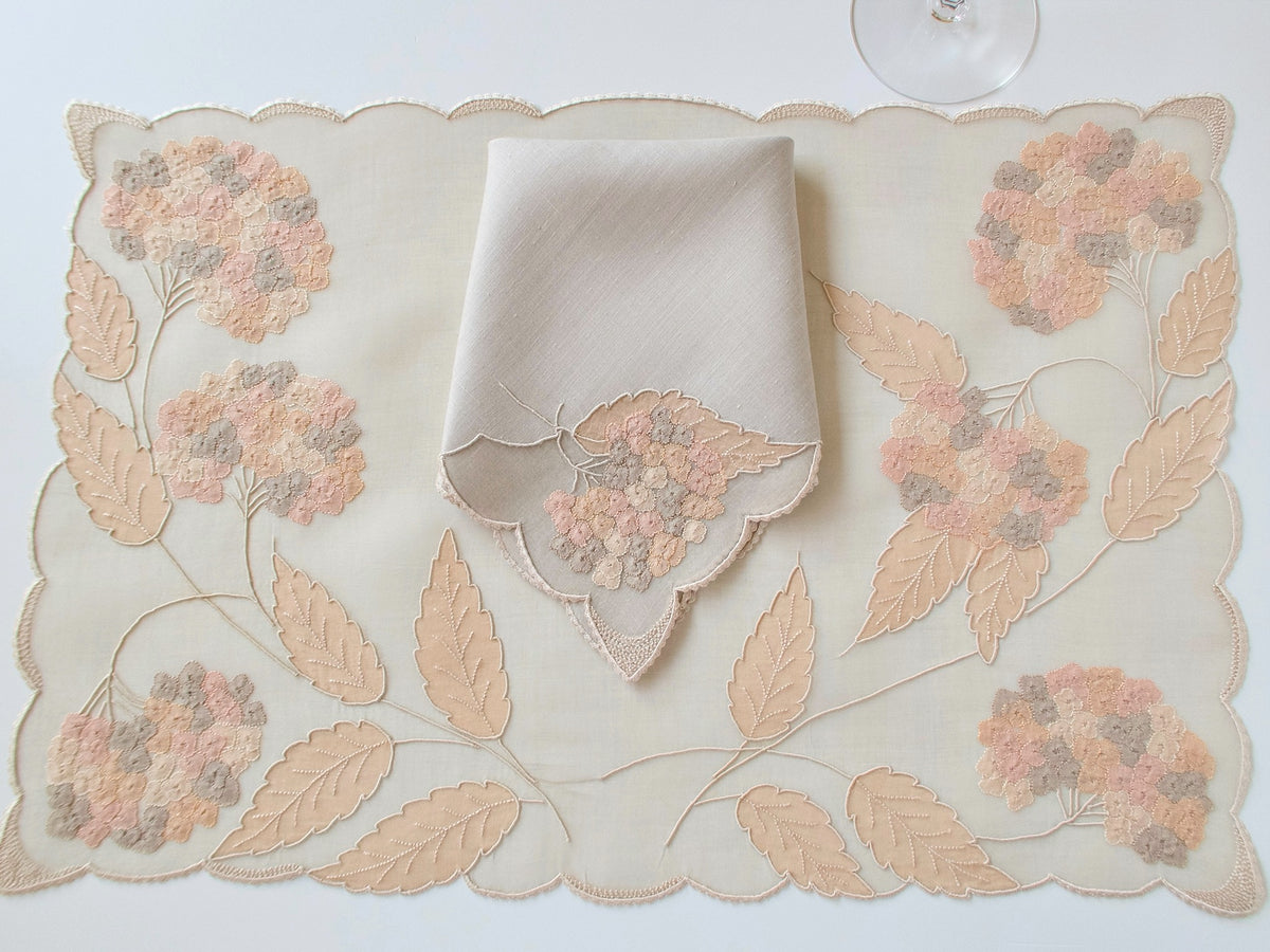 Vintage Marghab “Hydrangea” placemat and napkin set, hand embroidered in Madeira on fine organdy and linen, featuring intricate hydrangea blossoms in soft shades of cream and beige.