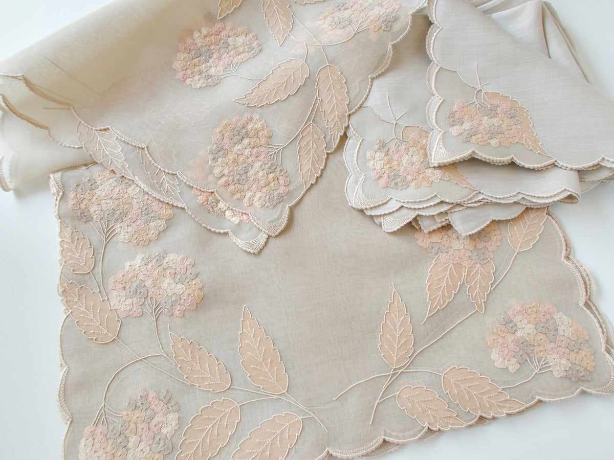 Vintage Marghab “Hydrangea” placemat and napkin set, hand embroidered in Madeira on fine organdy and linen, featuring intricate hydrangea blossoms in soft shades of cream and beige.