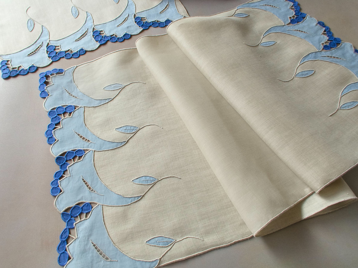 Vintage Marghab “Trumpet Flower” placemat and napkin set with matching table runner, hand embroidered in Madeira in layered blue organdy appliqué with raised trumpet blossom motifs and cutwork detailing.