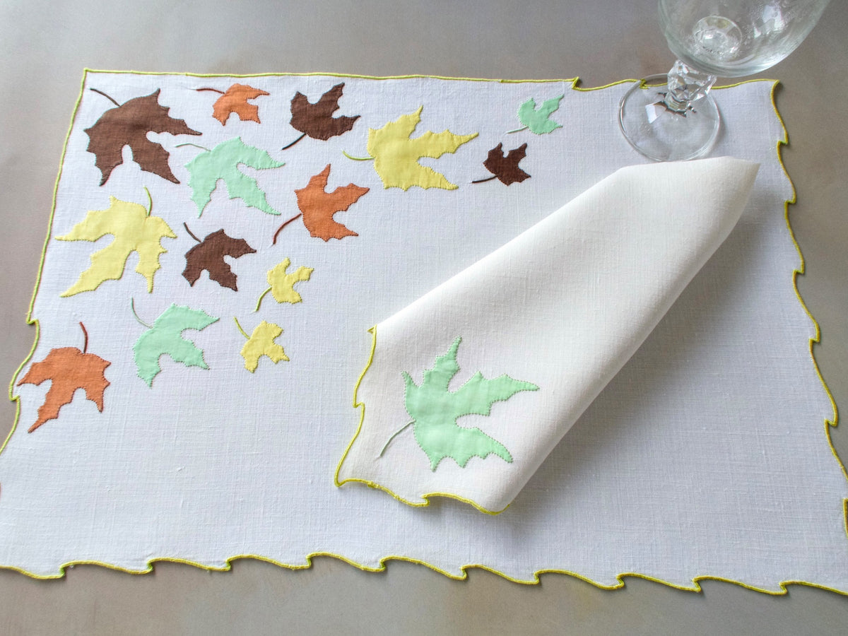 Vintage Marghab “Autumn Leaves” placemat and napkin set, hand embroidered in Madeira on fine linen with appliquéd fall leaves in rich tones edged in chartreuse embroidery.