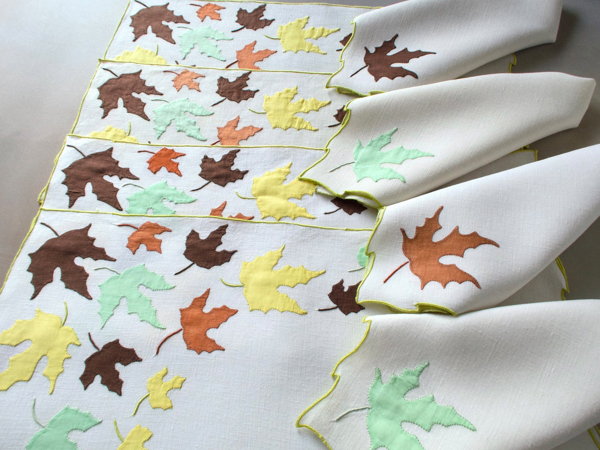 Vintage Marghab “Autumn Leaves” placemat and napkin set, hand embroidered in Madeira on fine linen with appliquéd fall leaves in rich tones edged in chartreuse embroidery.