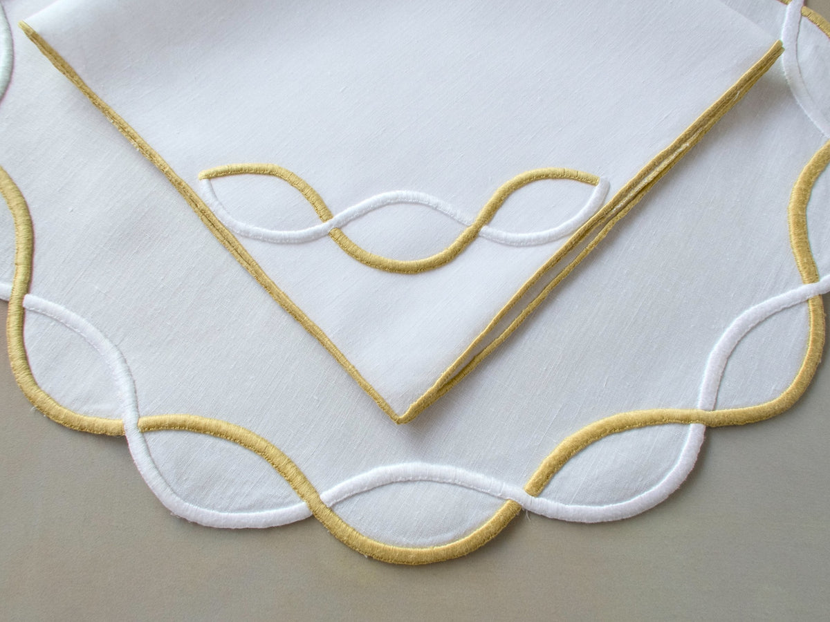Vintage Marghab “Andante” linen placemat and napkin set, hand embroidered in gold and white on fine linen, featuring the signature looping motif from the rare Andante pattern