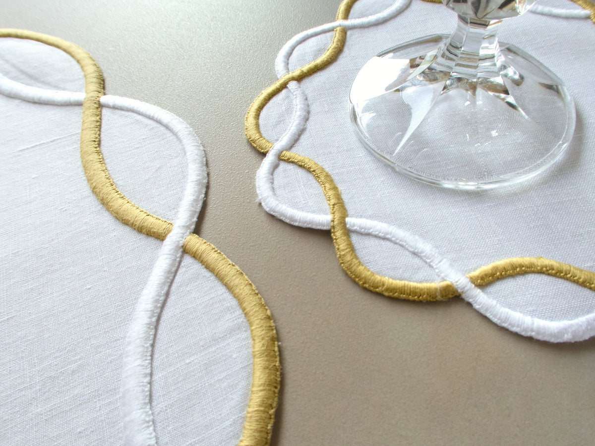 Vintage Marghab “Andante” linen placemat and napkin set, hand embroidered in gold and white on fine linen, featuring the signature looping motif from the rare Andante pattern