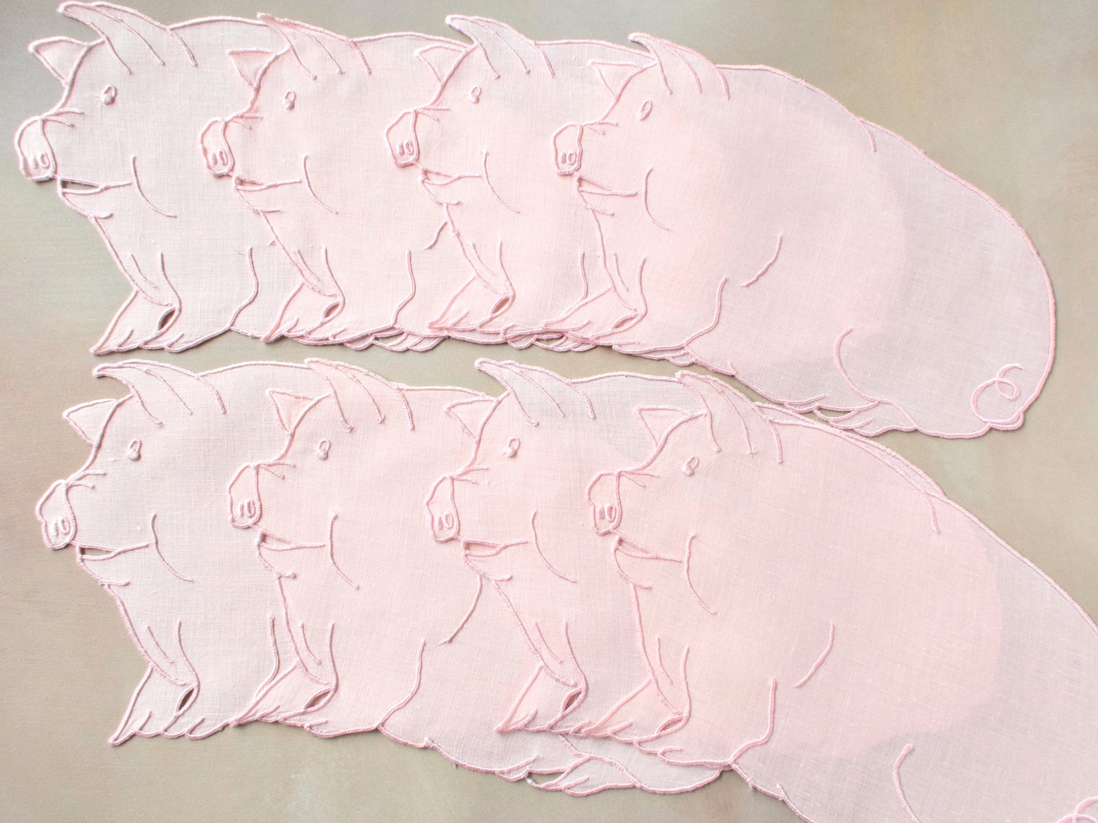 Pink pig-shaped vintage Madeira cocktail napkins on Irish linen, set of six, showing expressive embroidered faces and shaped edges.