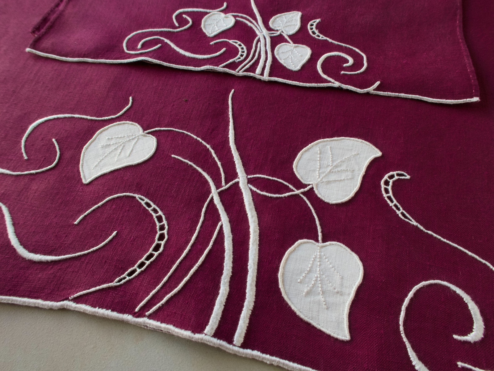 Marghab linen towels in the “Water Leaf” pattern, hand embroidered in plum on fine linen — guest and fingertip sizes shown together.