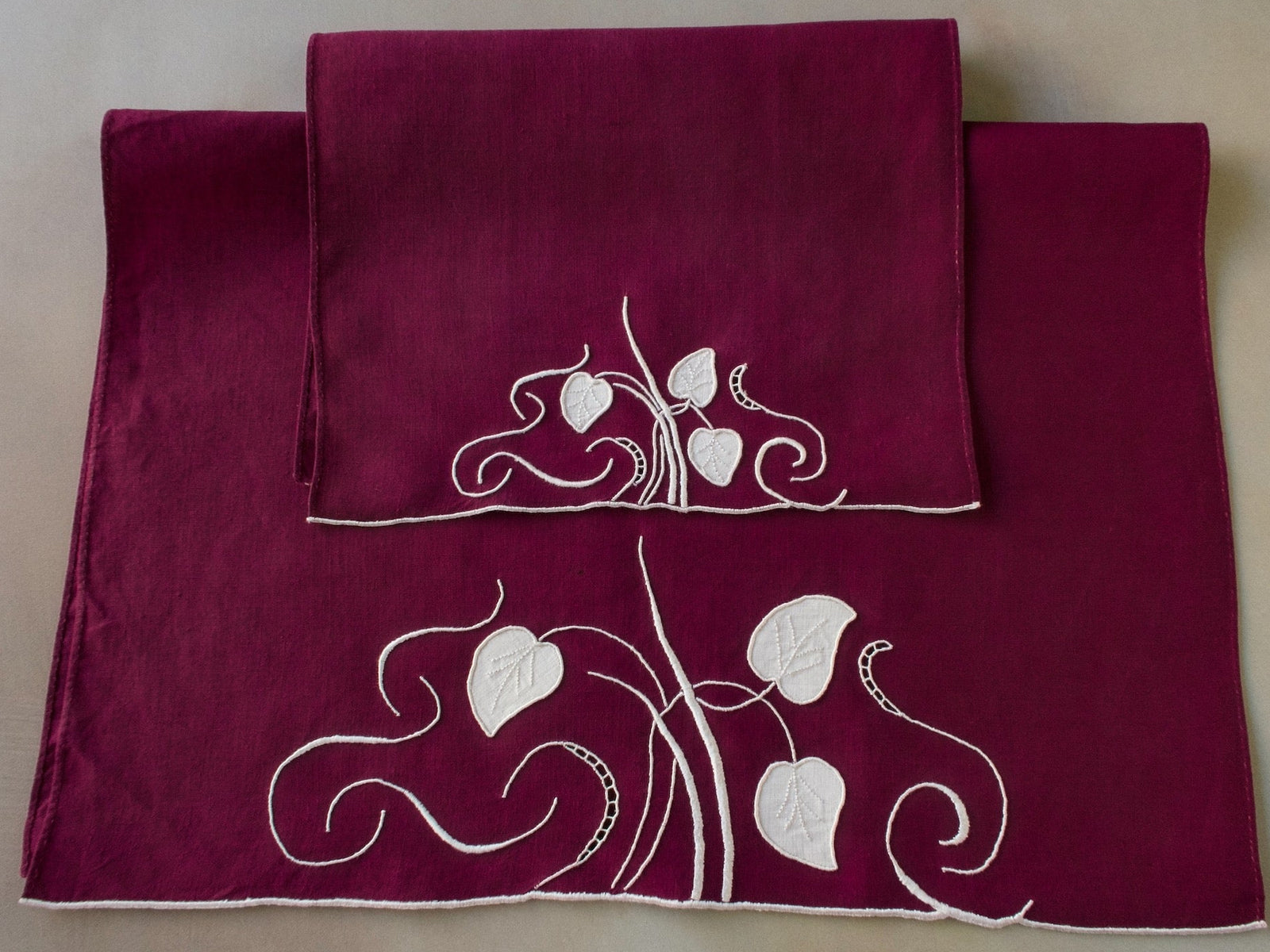 Marghab linen towels in the “Water Leaf” pattern, hand embroidered in plum on fine linen — guest and fingertip sizes shown together.