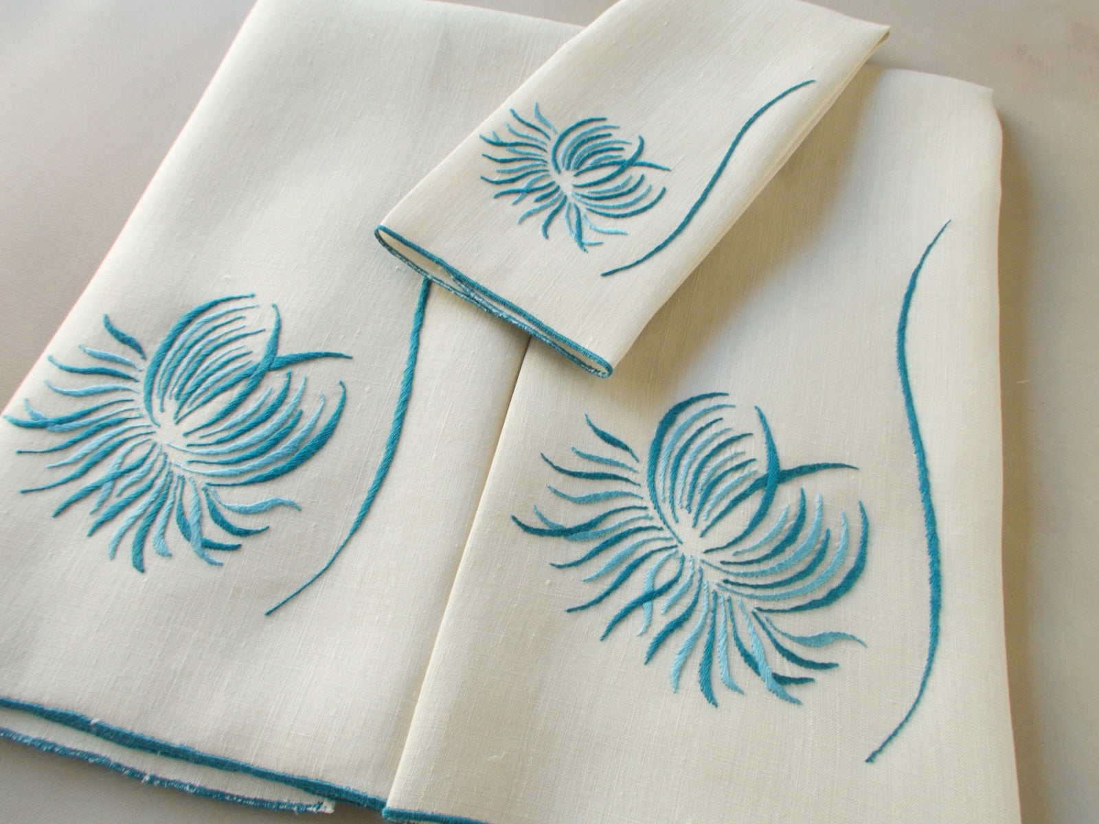 Marghab “Chrysanthemum” linen towel set with two guest towels and one fingertip towel, finely embroidered in Madeira in a graceful floral design.