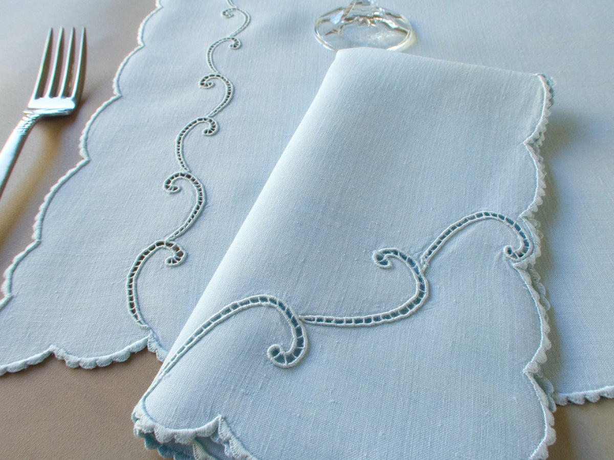 Blue Marghab “Simplicity” placemat and napkin set with scrolling cutwork and caseado bastido edging, embroidered on fine linen, handmade in Madeira.